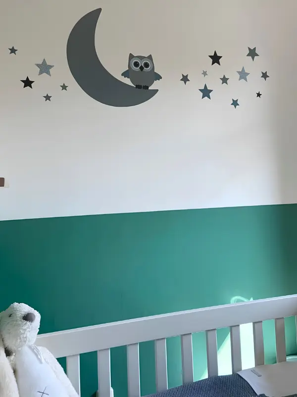Groene babykamer met een oudgroene uil op maan behangsticker.